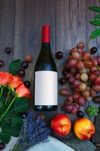Wine bottle with grapes and flowers for tasting event.