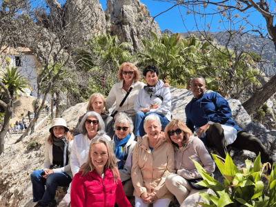 Group of hikers enjoying a trail with scenic mountain views and lush greenery.
