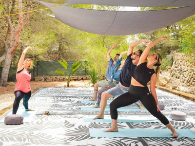Yoga class outdoors at Oodles Retreat, surrounded by nature.